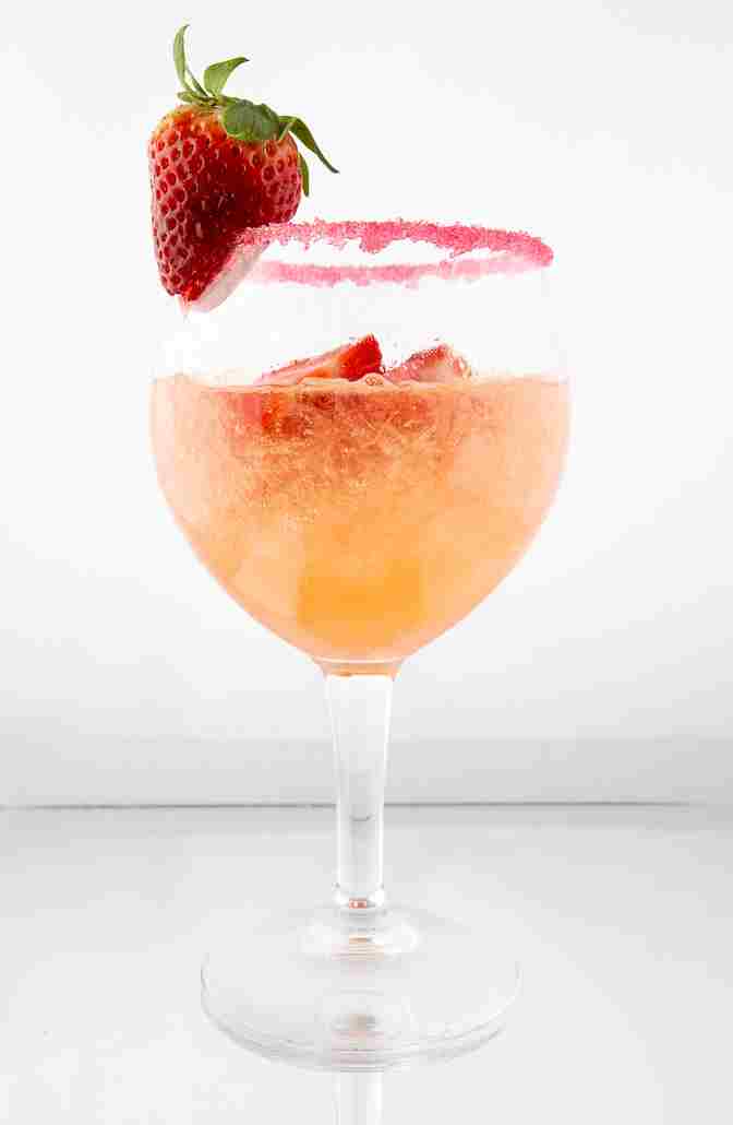 Side-view of a well presented drink with the glass decorated with a strawberry